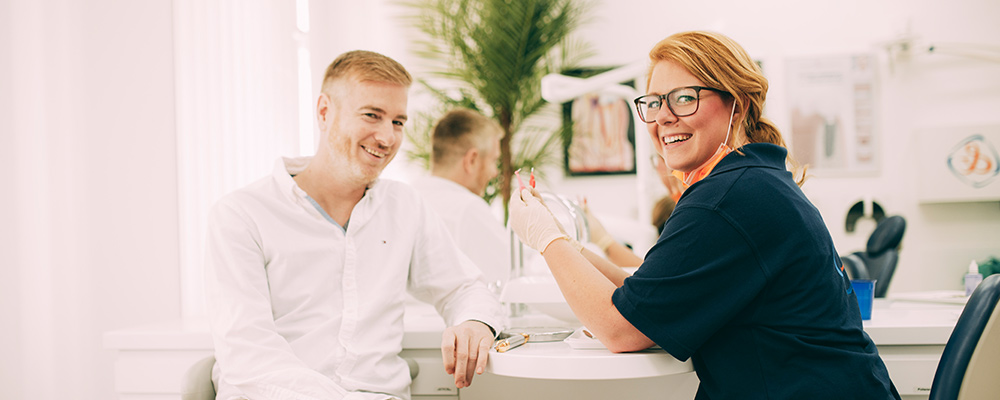 Professionelle Zahnreinigung (PZR) in Coronazeiten, Mitarbeiterin erklärt die Vorgehensweise.